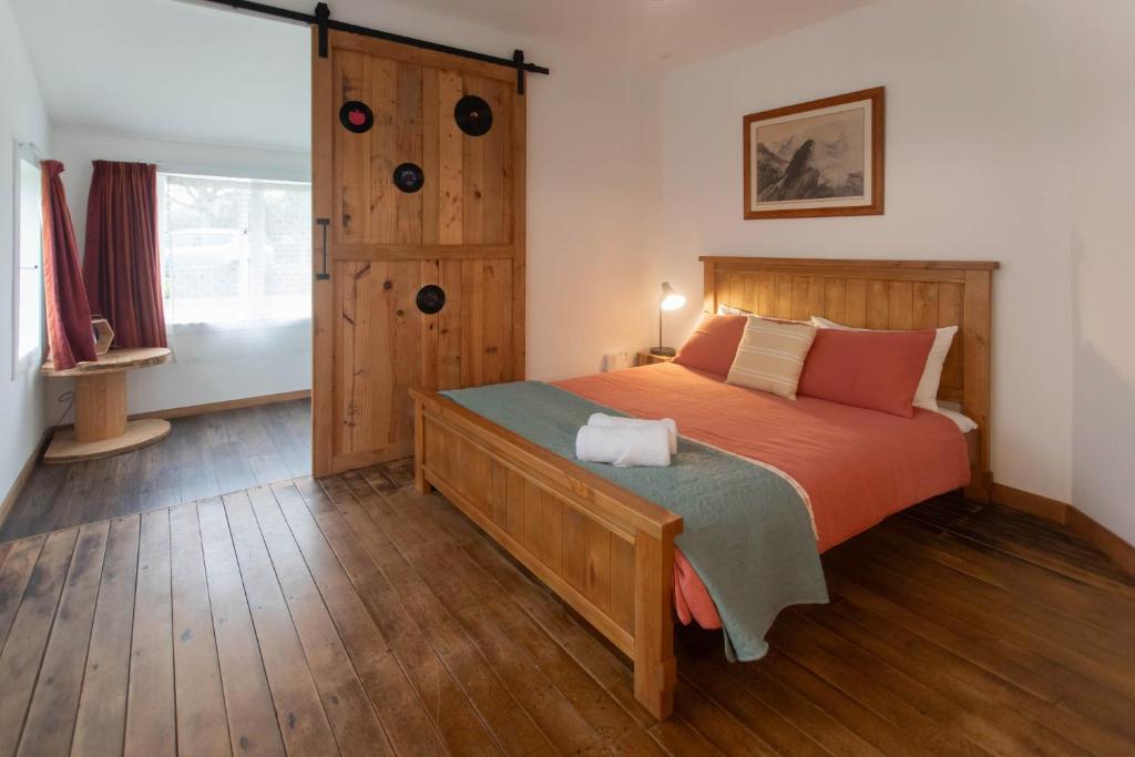 1 dormitorio con 1 cama grande con sábanas de color naranja en Devon Eleven en Rotorua