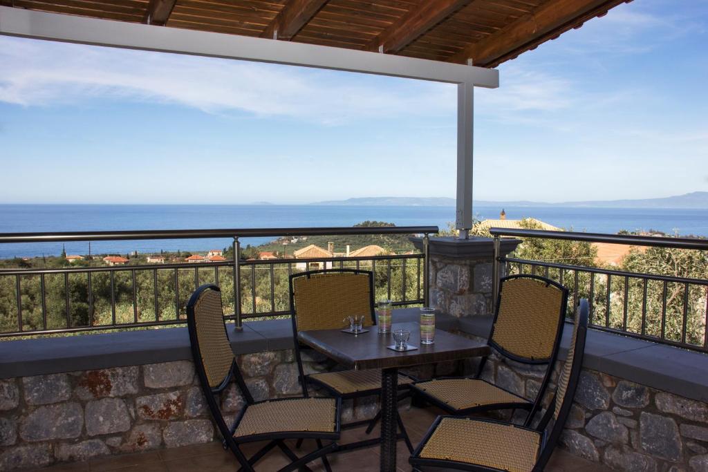 a patio with a table and chairs on a balcony at Emilia's Guest House Upper Floor in Stoupa