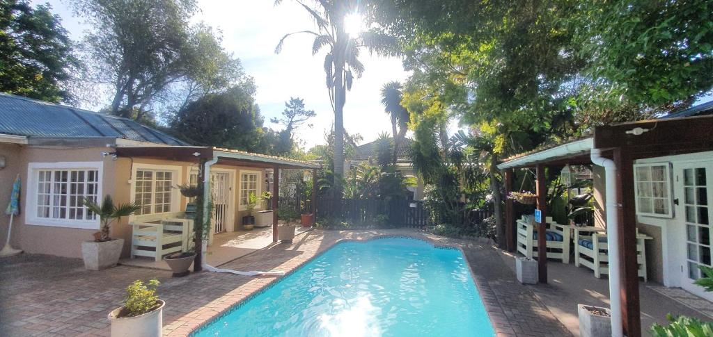 a swimming pool in front of a house at Paradise in the City Cottage Two in Port Elizabeth