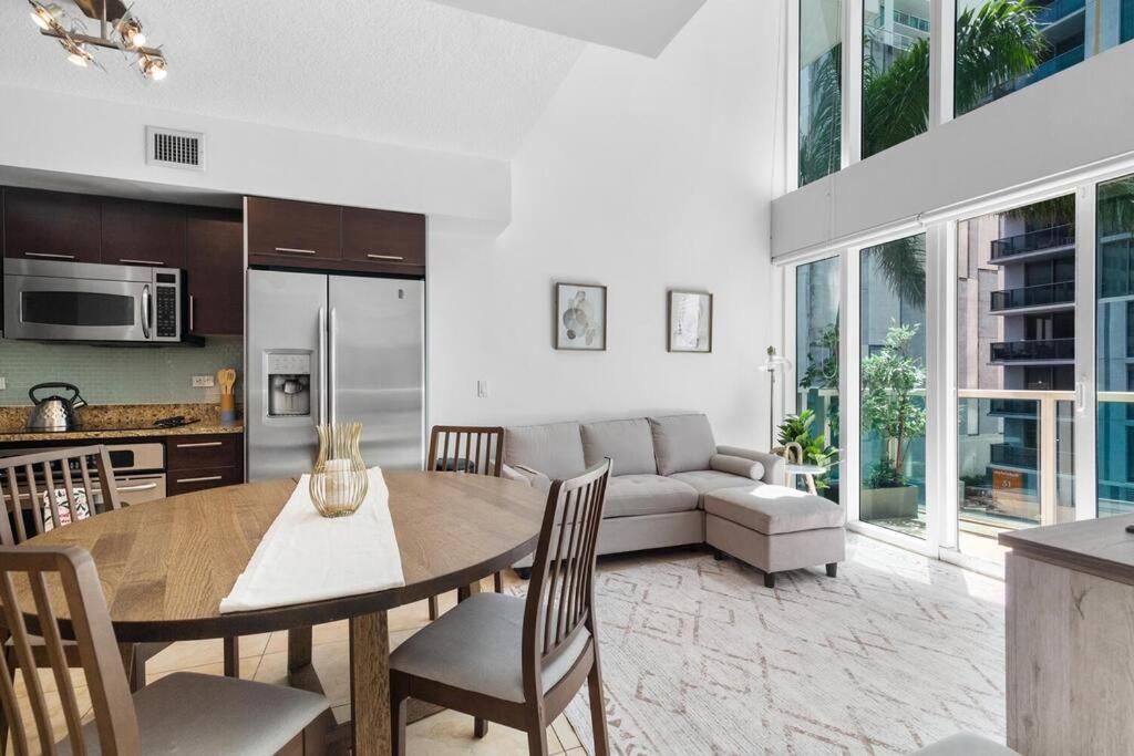 - un salon avec une table et un canapé dans l'établissement Brickell 2 Story Luxury Getaway With Pool, à Miami
