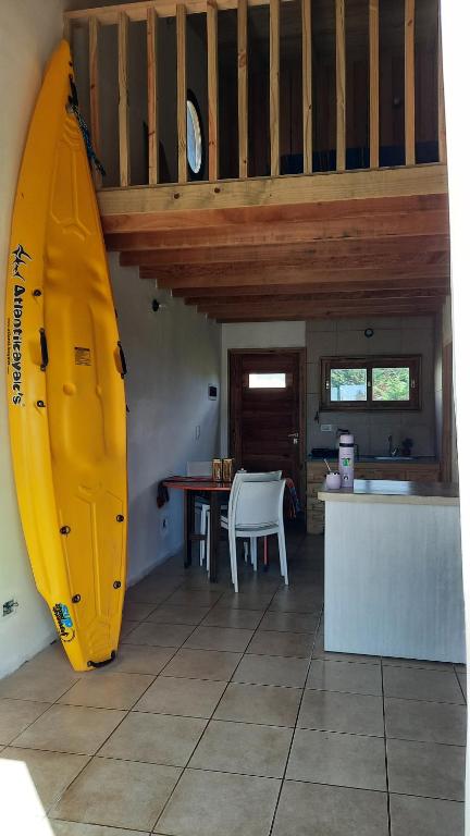 une grande planche de surf jaune dans une cuisine avec une table dans l'établissement AMARRA Camet Norte, à Santa Clara del Mar