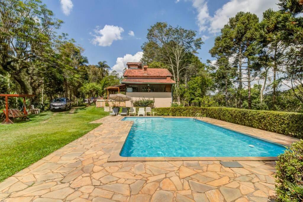 - une piscine dans une cour avec une maison dans l'établissement Sitio CANTOS DA FLORESTA, à Mairinque