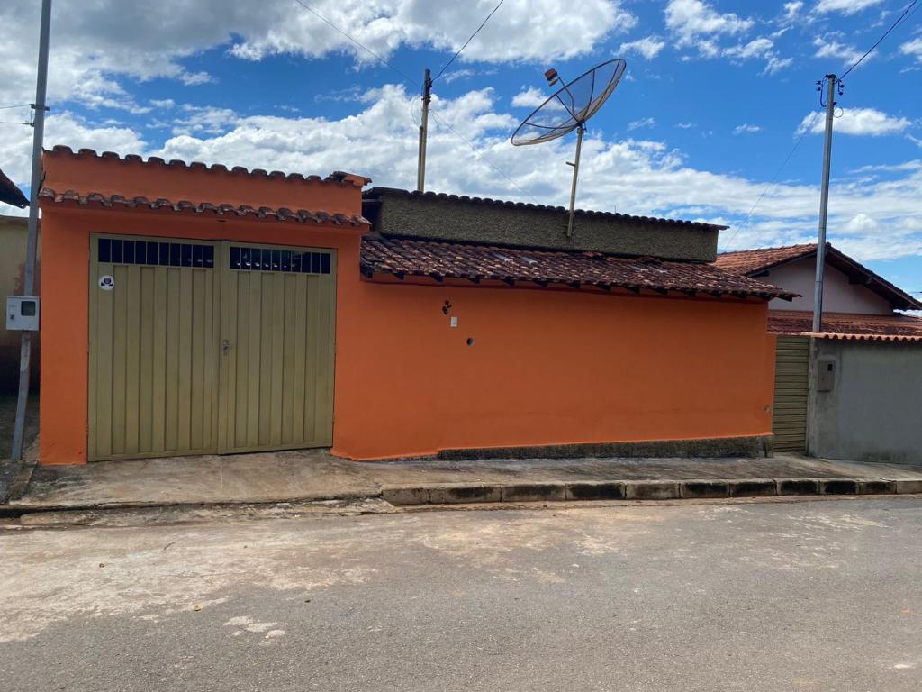 a building with a green and orange garage at CASA NA SERRA in São Roque de Minas