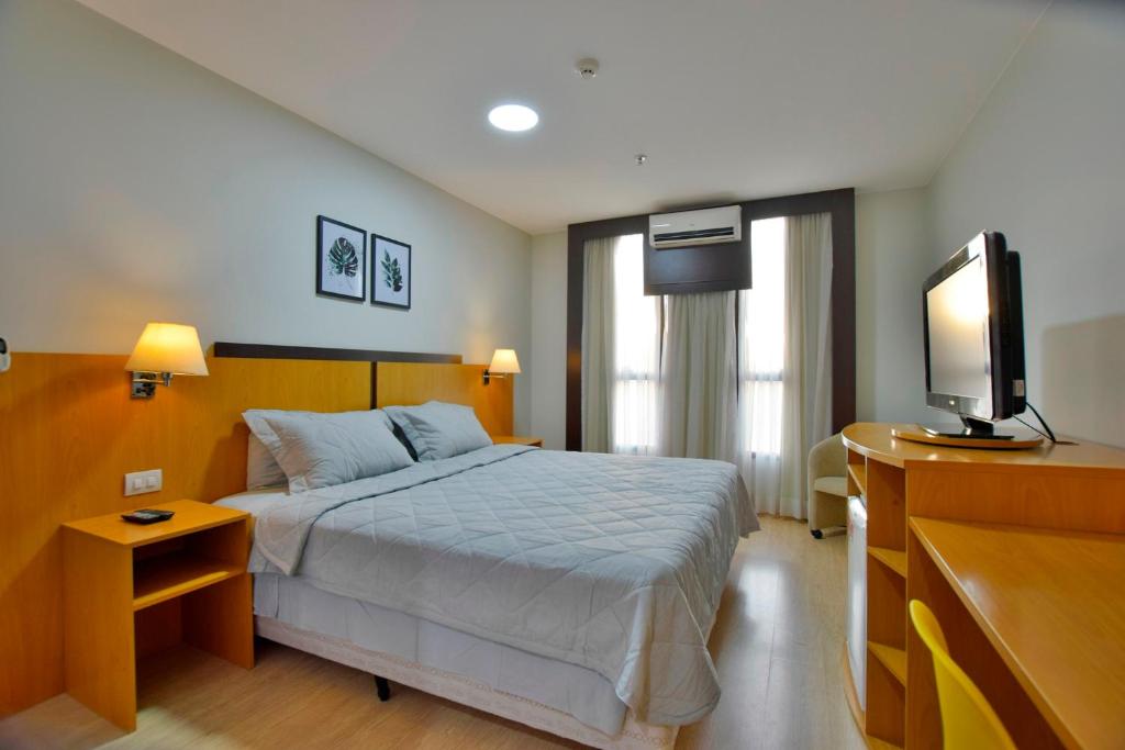 1 dormitorio con 1 cama y TV de pantalla plana en Comfort Hotel Taguatinga - Flat Preferido c/ Wifi en Brasilia