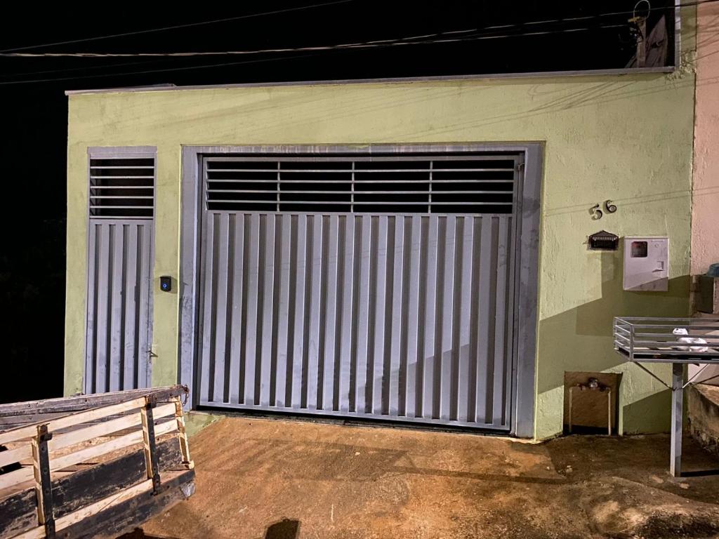 una gran puerta metálica de garaje en una habitación con banco en Casa Bela Vista, en São Roque de Minas