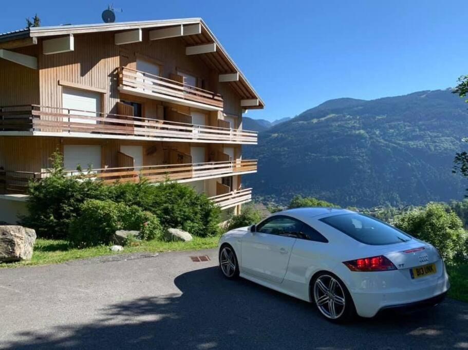 une voiture blanche garée devant un immeuble dans l'établissement Turquoise 551, à Saint-Gervais-les-Bains