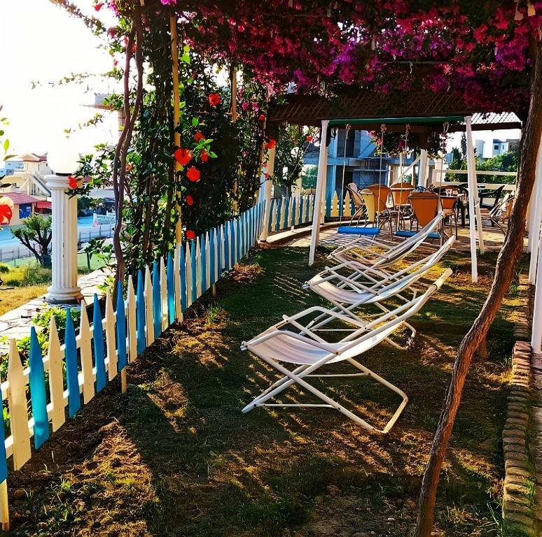 un grupo de sillas de jardín sentadas junto a una valla en Hotel Sirena, en Vlorë
