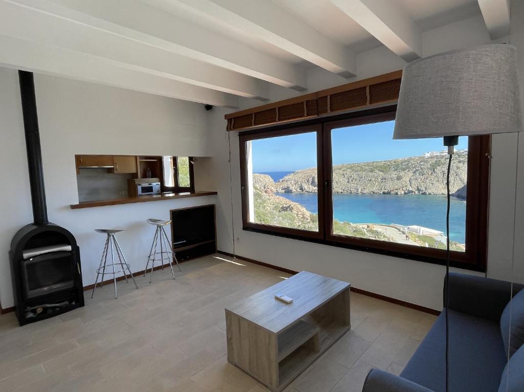 uma sala de estar com uma grande janela com vista em Apto. Ses Ancolles Vistas Mar em Cala Morell