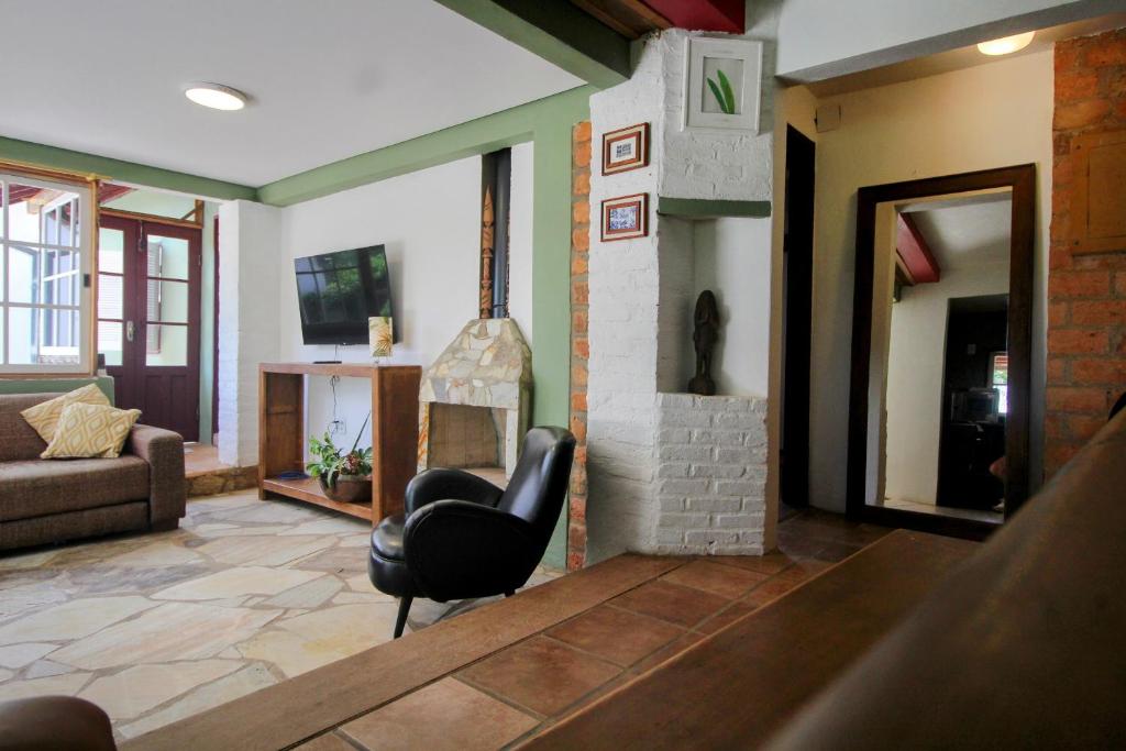 ein Wohnzimmer mit einem Stuhl und einem Kamin in der Unterkunft Casa da Vila in Tiradentes