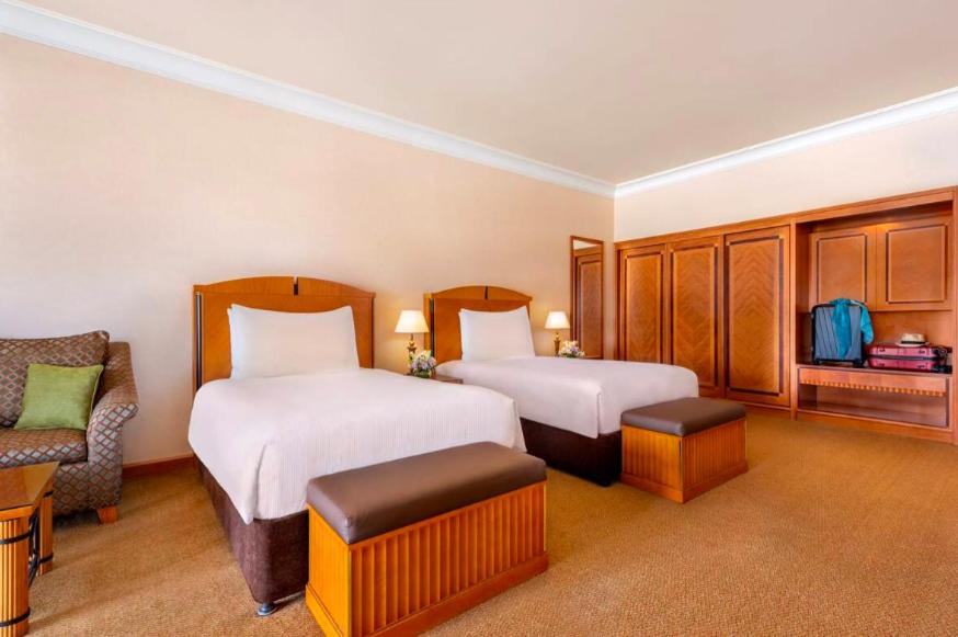 a hotel room with two beds and a couch at Al Raha Beach Hotel - Superior Room DBL - UAE in Abu Dhabi