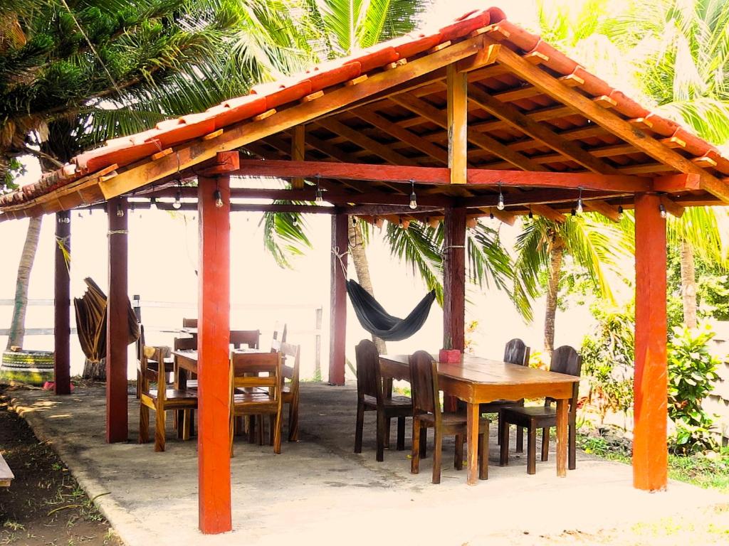 um pavilhão de madeira com uma mesa e cadeiras de madeira em Casa Reyna em Moyogalpa