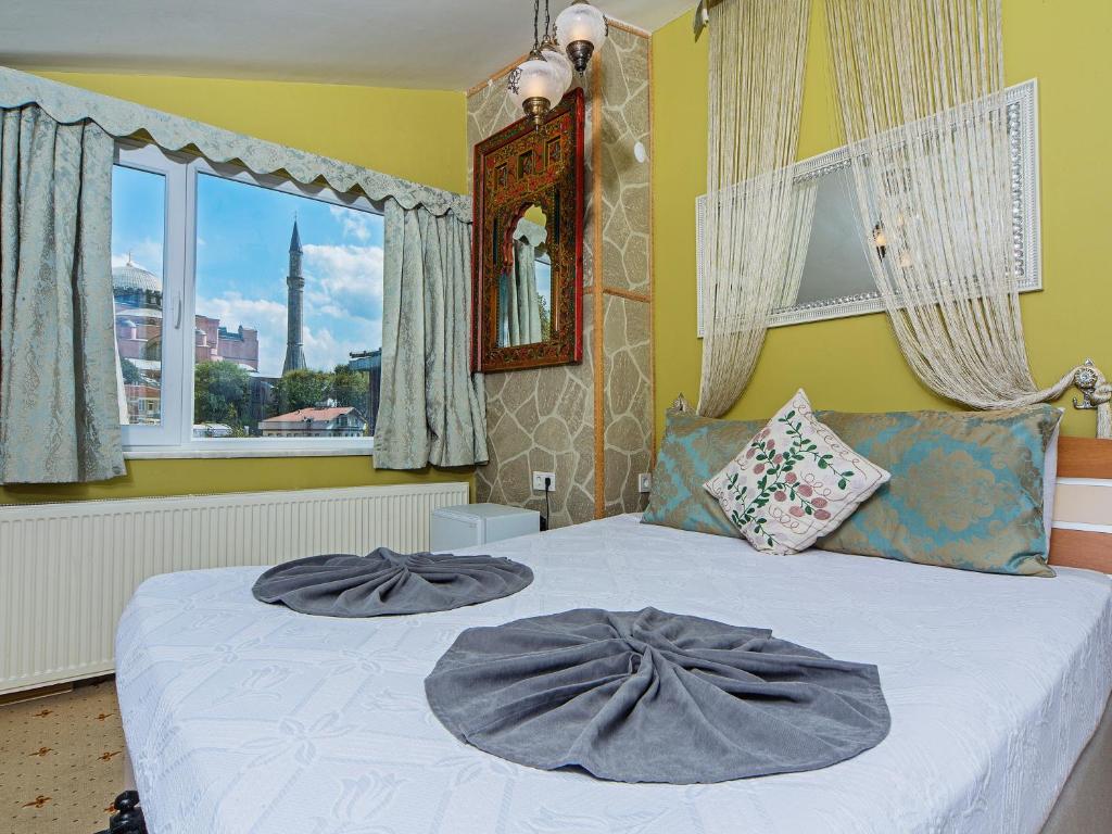 a bedroom with a bed with two gray pillows on it at Modern Sultan Hotel in Istanbul