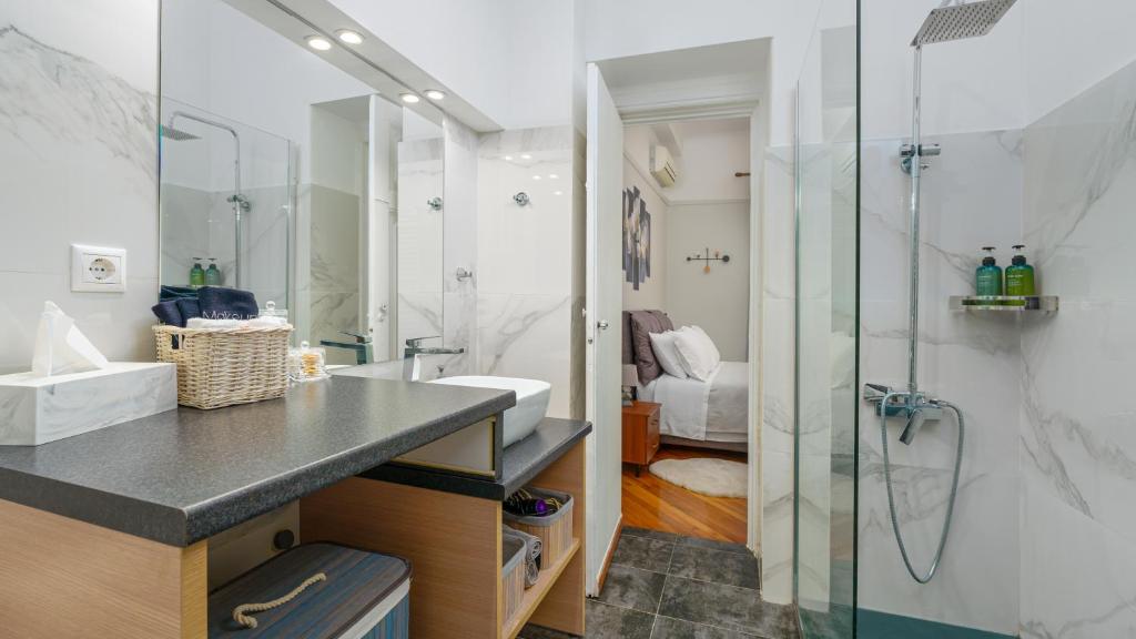 y baño con ducha acristalada y lavamanos. en Plaka Sofi Suite en Atenas