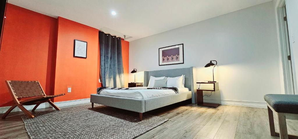 ein Schlafzimmer mit einem Bett und einer orangefarbenen Wand in der Unterkunft The Lofts on Clematis 306 Downtown West Palm Beach in West Palm Beach