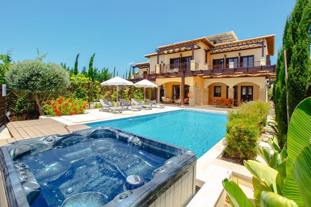 a house with a swimming pool in front of a house at Luxury Villa AJ 06 with private heated pool in Paphos City