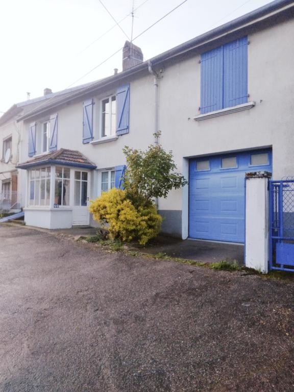 una casa bianca e blu con un garage blu di La Maisonnette de Suzette a Port-sur-Saône