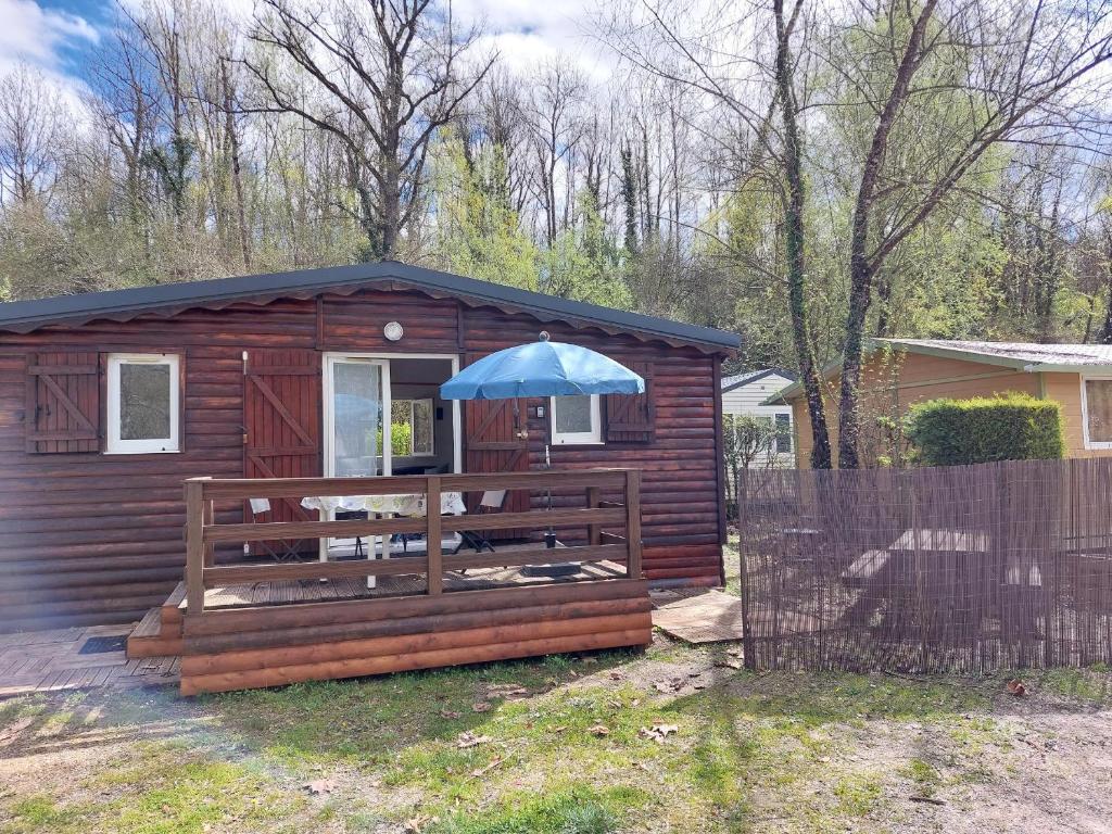 a small cabin with an umbrella on a deck at Chalet 6 places in Saint-Thomas-en-Royans