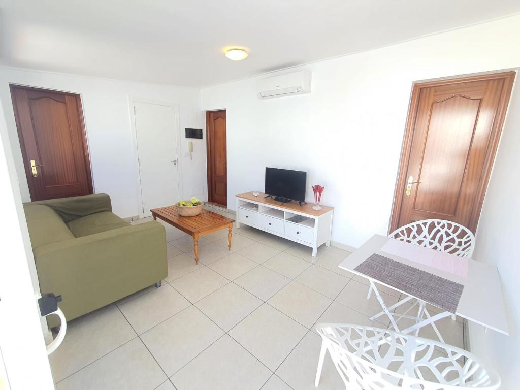 een woonkamer met een bank en een tv bij Bubu Beach 5 Ático in Los Cristianos