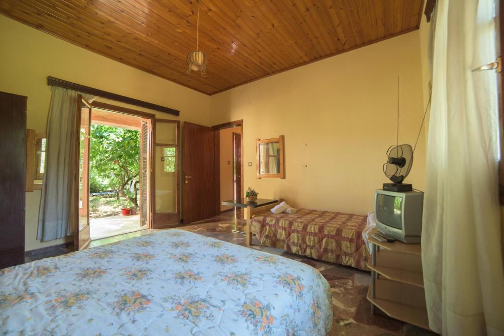 a bedroom with a bed and a tv in it at Mary's Garden House in Peroulades