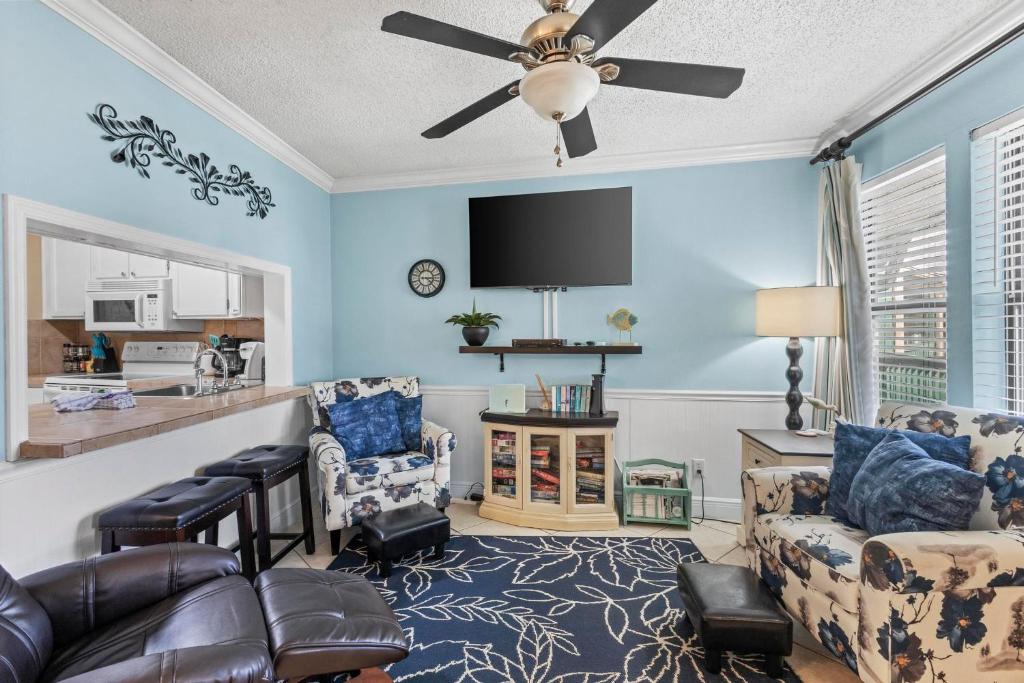 a living room with blue walls and a ceiling fan at Sea Breeze 311 in Gulf Shores