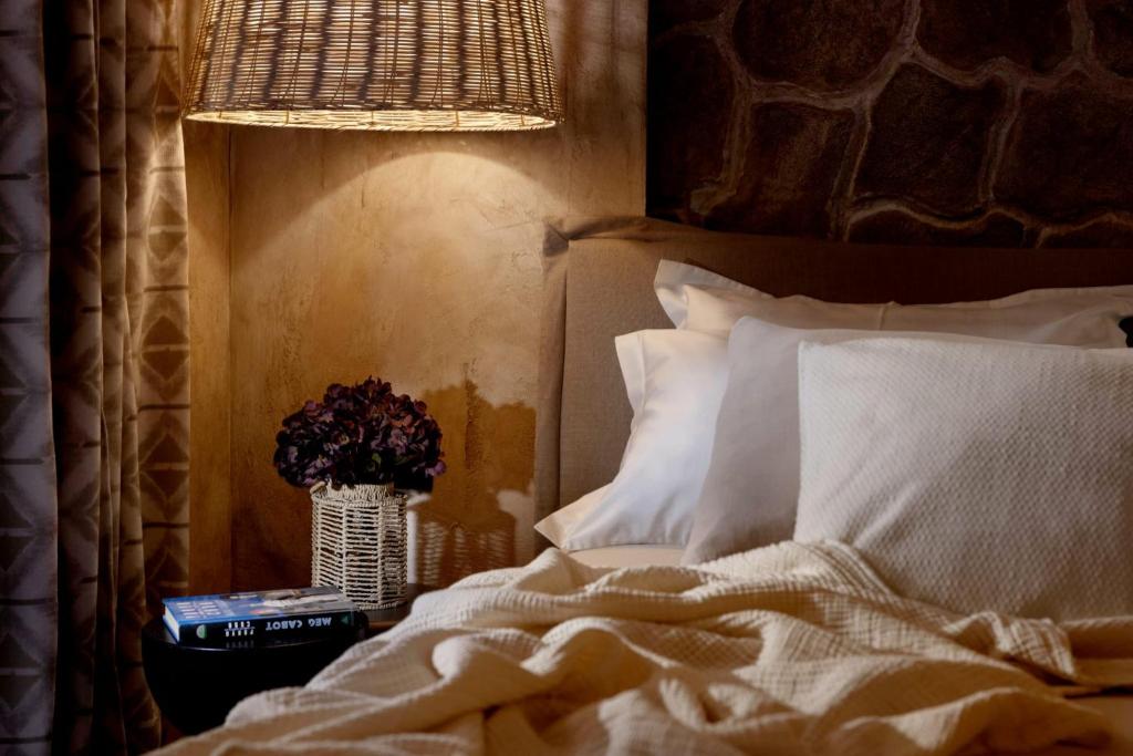 1 dormitorio con 1 cama y un jarrón de flores en LaMaison Dubrovnik, en Dubrovnik