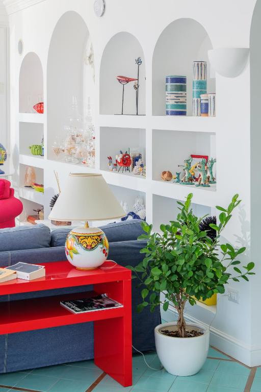 a living room with a blue couch and a red table at Hotel Le Terrazze in Conca dei Marini