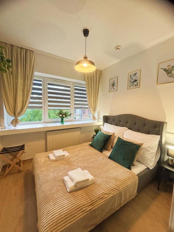 a bedroom with a large bed with towels on it at Great Polonia Kraków City Center in Kraków