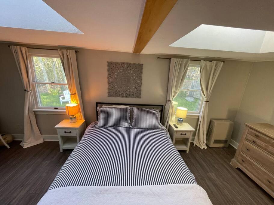 a bedroom with a large bed with two lamps on two tables at Pet Friendly 2 BR House in Southwest Harbor! [Hillside Cottage] in Southwest Harbor