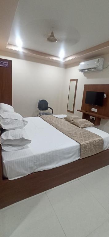 a bedroom with a large bed and a television at Kuber Residency in Tirupati