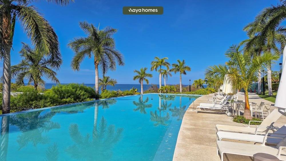 uma piscina com cadeiras e palmeiras em 03 F2 Bolongo-PV em Punta Mita