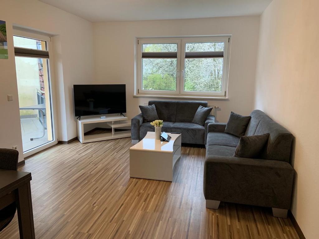 ein Wohnzimmer mit 2 Sofas und einem TV in der Unterkunft BestBoarding24 in Schöllkrippen