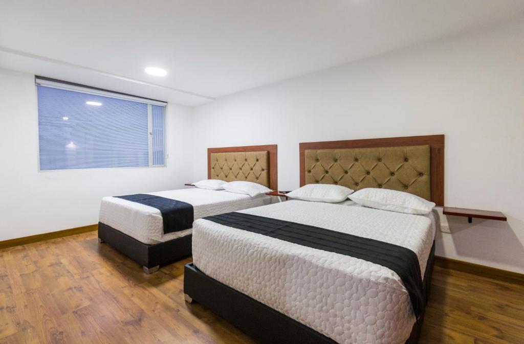 a bedroom with two beds and a window at Hotel Casa Botero 201 in Bogotá