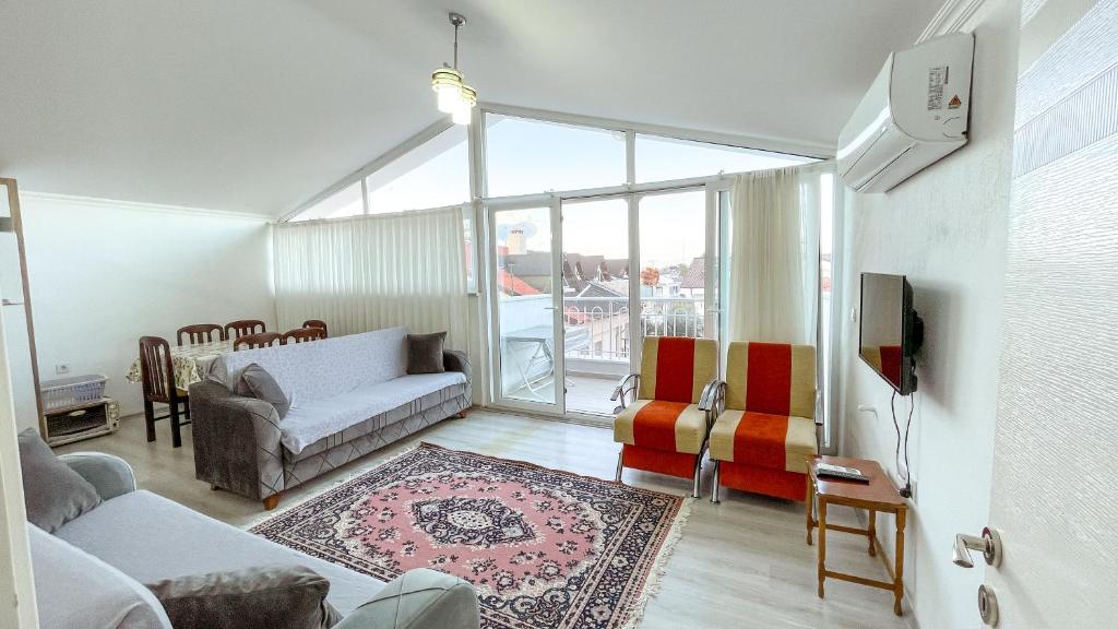 ein Wohnzimmer mit einem Sofa und ein Wohnzimmer mit einem Fenster in der Unterkunft Kaan Apart (Ortaca/Dalyan Merkezde) 2+1, 70m2 in Ortaca
