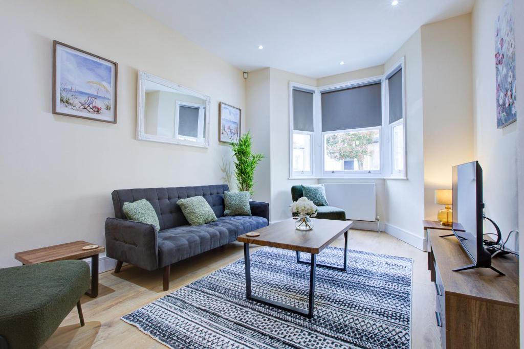 a living room with a couch and a tv at Stunning 4 Bedroom House in London