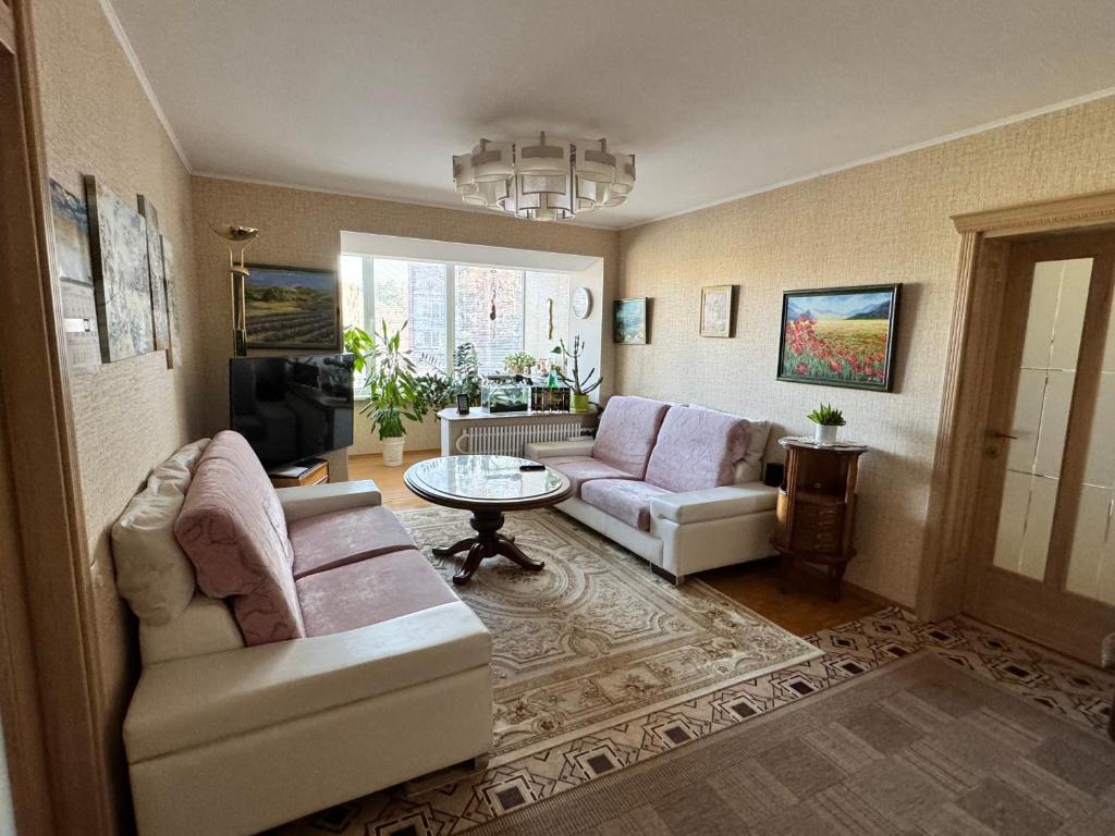 a living room with two couches and a table at VIsagino Apartment in Visaginas
