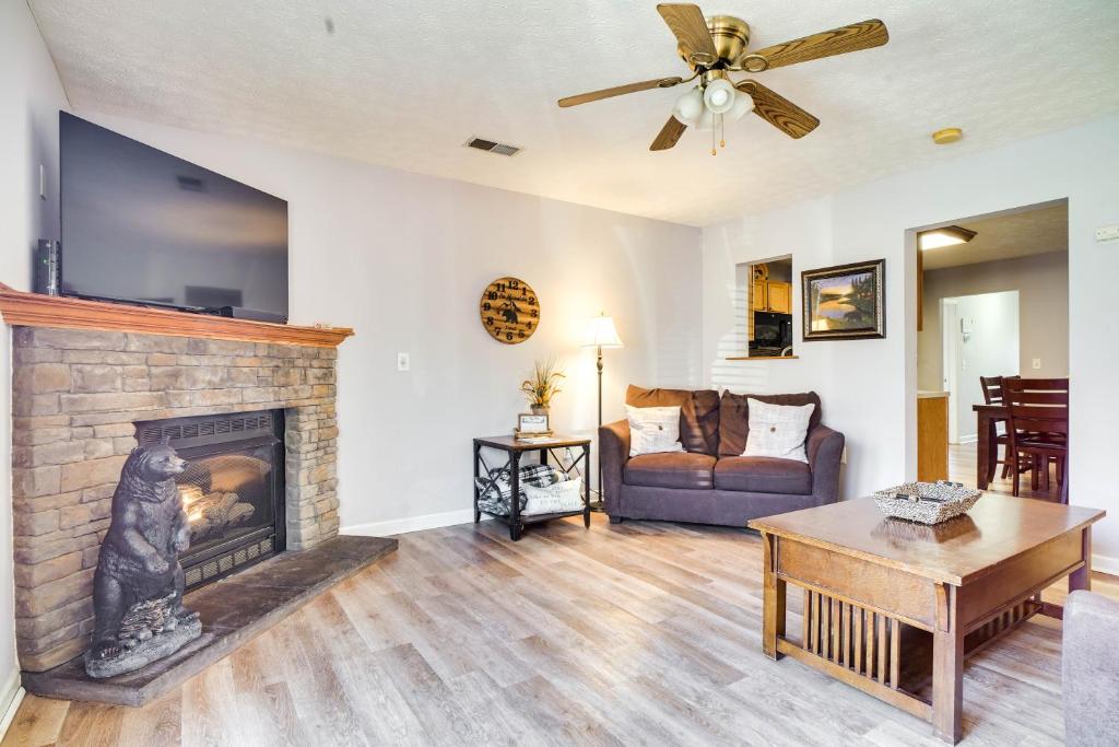 ein Wohnzimmer mit einem Kamin und einem Sofa in der Unterkunft Secluded Sevierville Condo with Hot Tub and Mtn Views! in Sevierville