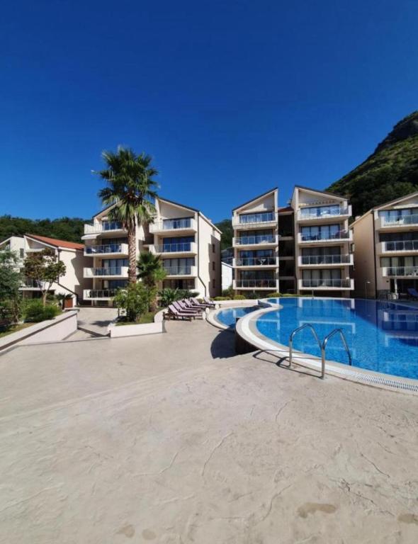a resort with a swimming pool and some buildings at Blue lagoon apartment Przno in Budva