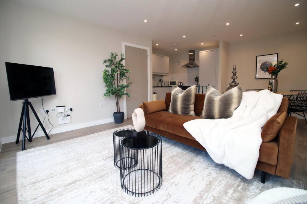 a living room with a brown couch and a kitchen at Casablanca 4 - Cardiff Bay - 2 Bed Apartment in Cardiff