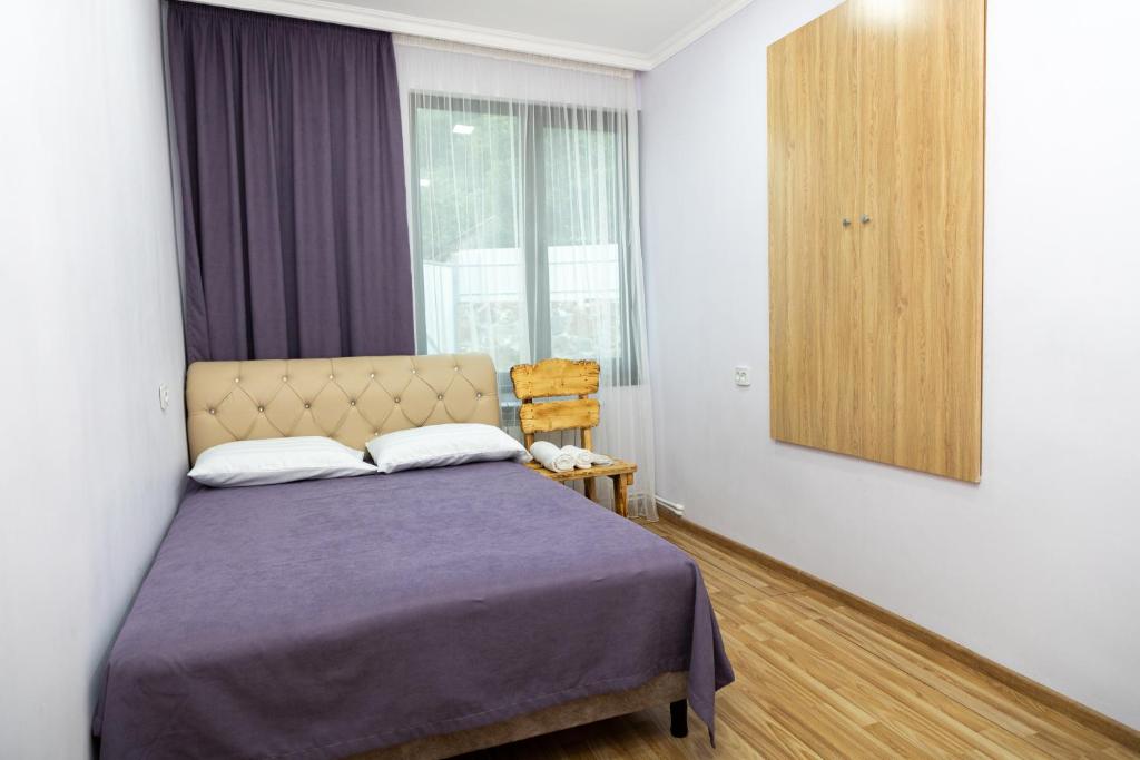 1 dormitorio con cama y espejo en Loly Luxury Guest House en Dilijan