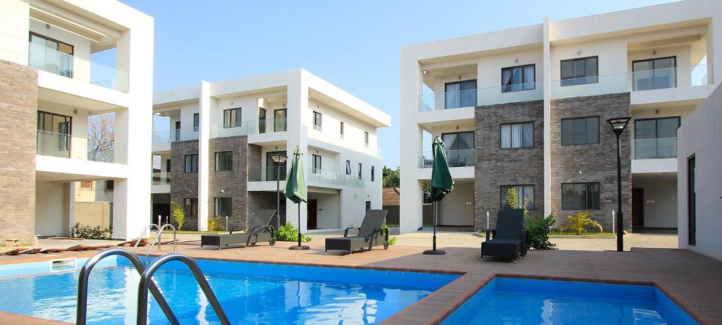 a swimming pool in front of a building at Stay Play Away Residences - Luxury 4 bed, Airport Residential, Accra in Accra