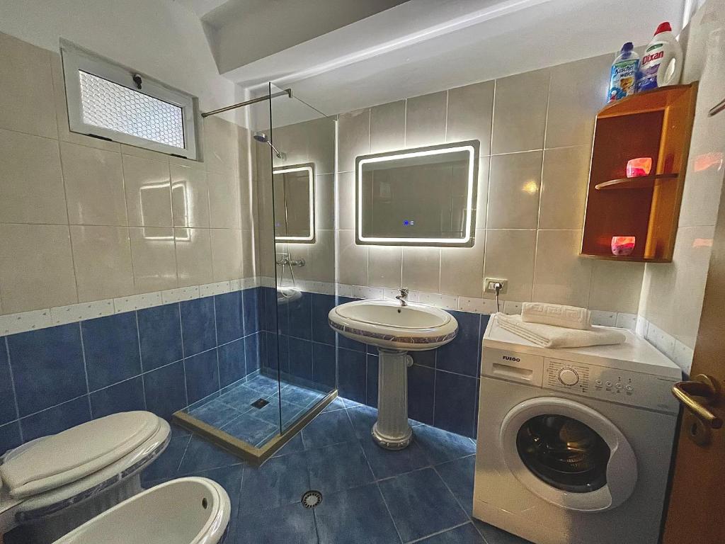 ein Badezimmer mit einem Waschbecken und einer Waschmaschine in der Unterkunft Alba Marina in Vlorë