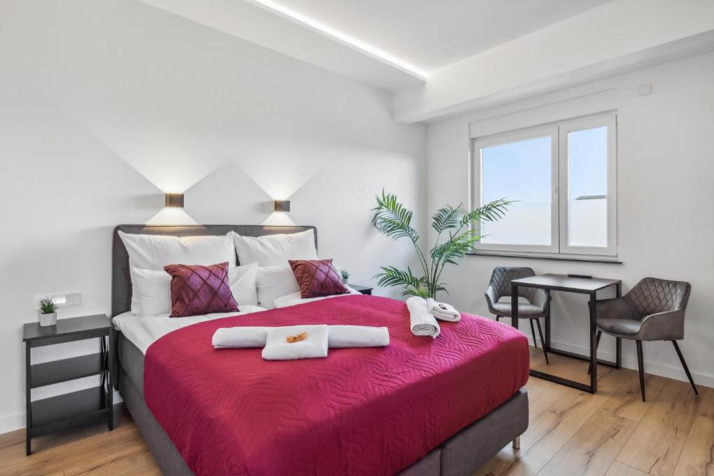 - une chambre avec un grand lit et une couverture rouge dans l'établissement SUITE4ME - Moderne Apartments I Küche I Balkon I Waschmaschine, à Dietzenbach