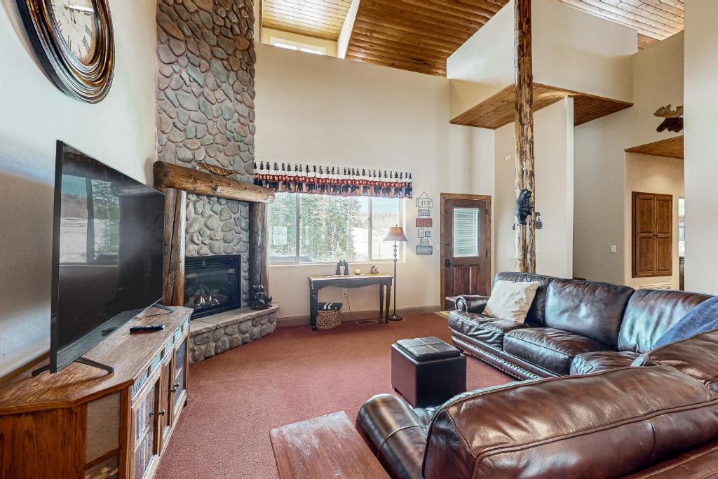 ein Wohnzimmer mit einem Ledersofa und einem Kamin in der Unterkunft Crooked River #18 in Brian Head