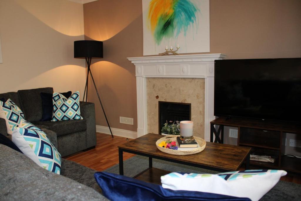 a living room with a couch and a table with a fireplace at 5 star, 5 Bedroom Home in Ely in Ely
