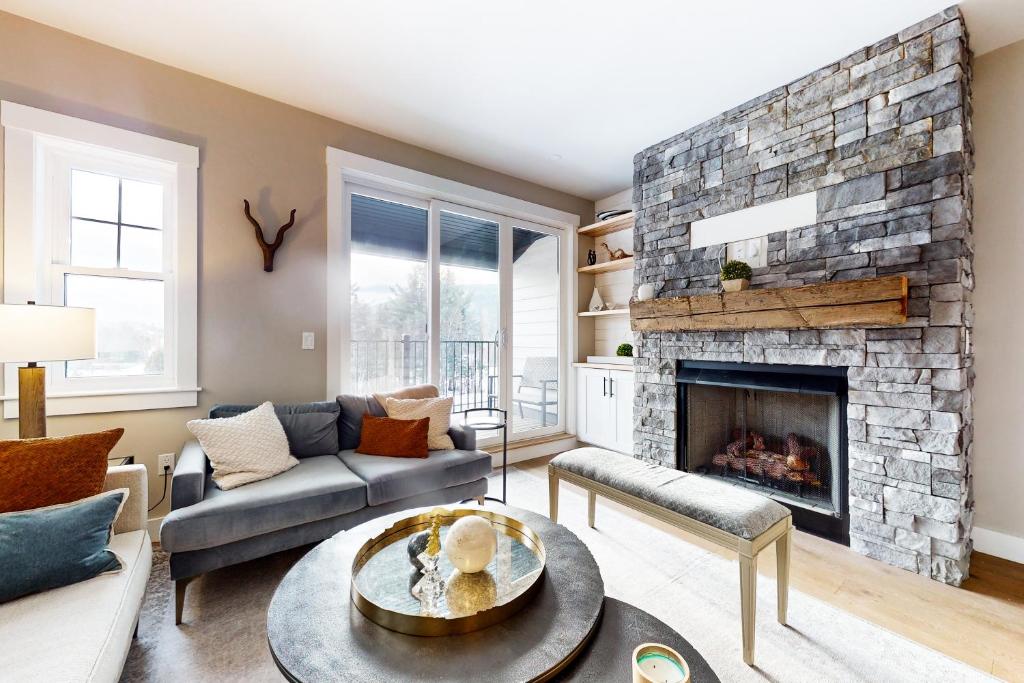 a living room with a stone fireplace at Mountain Sunset Villa in Waterville Valley