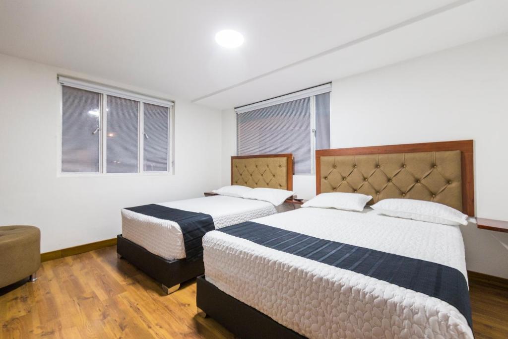 duas camas num quarto com duas janelas em Hotel Casa Botero 202 em Bogotá