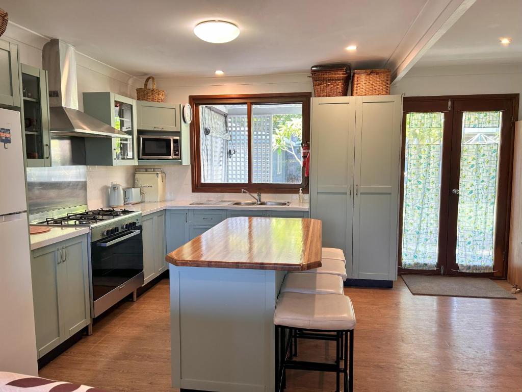 a kitchen with blue cabinets and a counter top at Camelot in Yamba