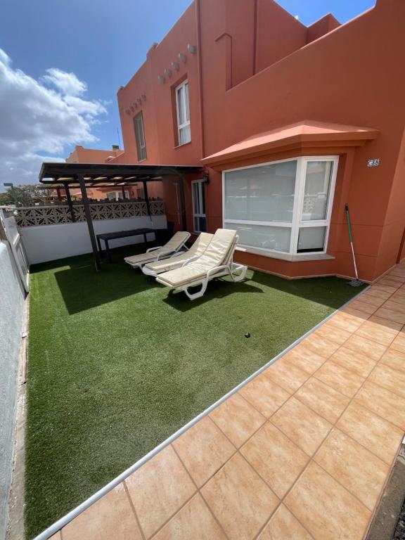 un patio con 2 sedie a sdraio e un gazebo di Aeren House a Corralejo