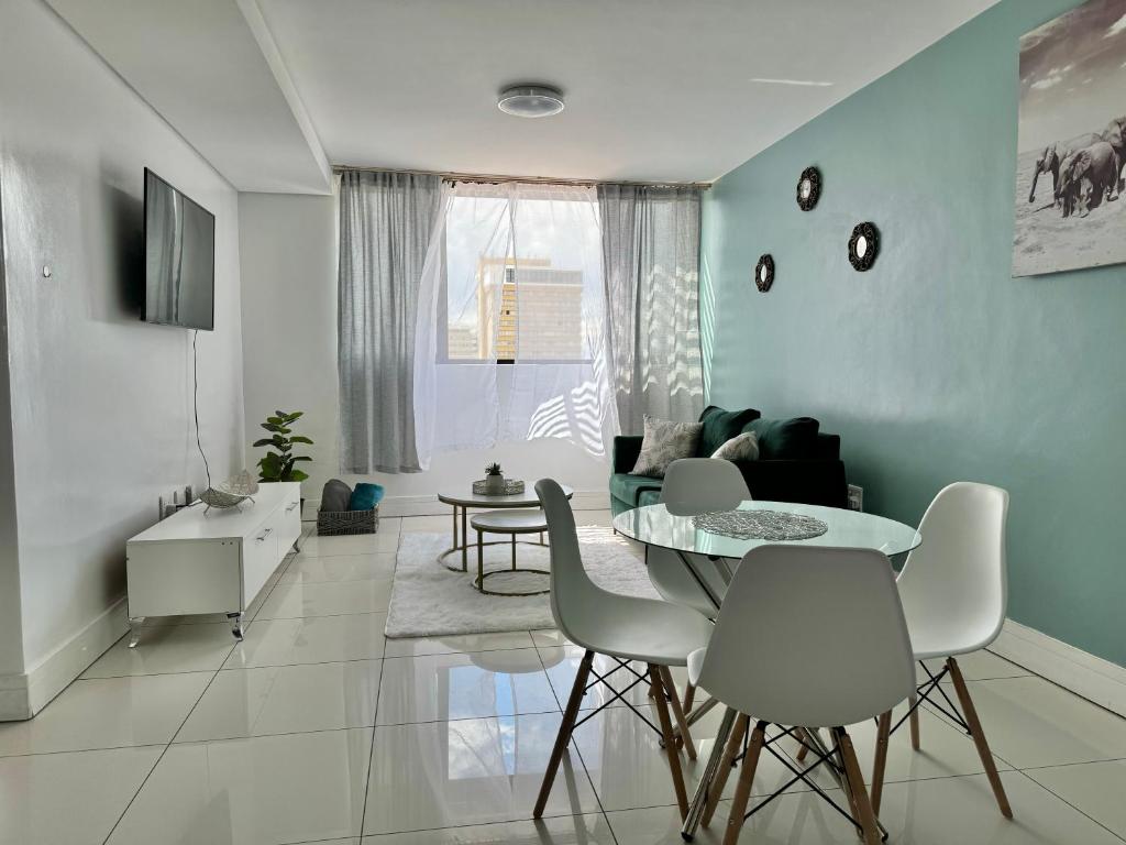 a living room with a table and chairs at Emy's City Center Flat at 77 on Independence in Windhoek