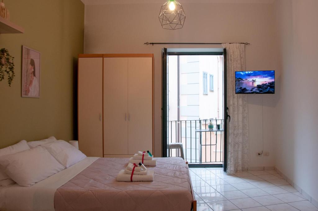 um quarto com uma cama e uma porta para uma varanda em Le Muse Loft em Caserta